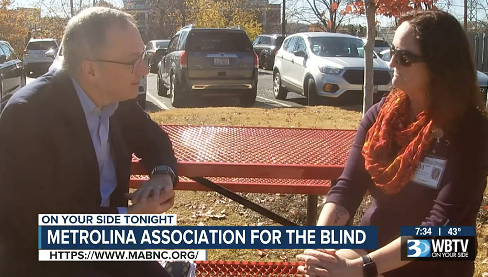 woman being interviewed at park bench by news reporter