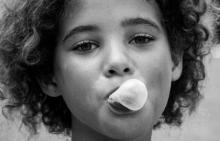 a child blows a bubble in gum