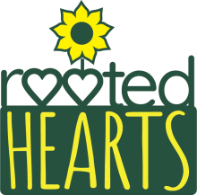 Rooted Hearts with two o's in the shape of a heart and a  sunflower. Logo is yellow and forest green.