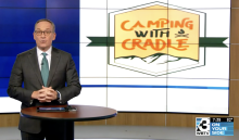 jamie boll at his tv desk with camping with cradle logo behind him